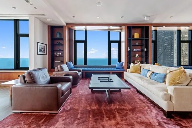 a living room with furniture and floor to ceiling windows