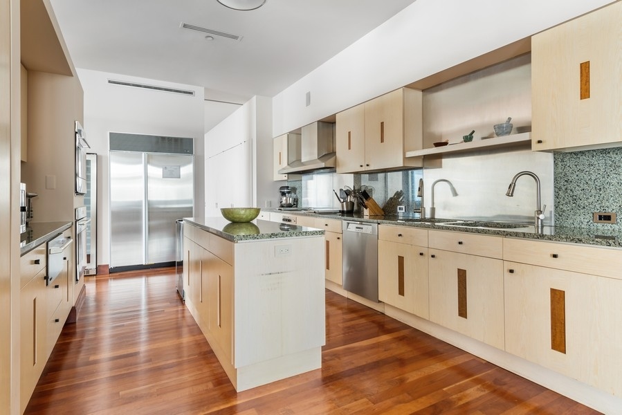 132 East Delaware Place, Unit 6502 Chicago, IL 60611 - Photo 10 of 27 a kitchen with granite countertop white cabinets and white appliances