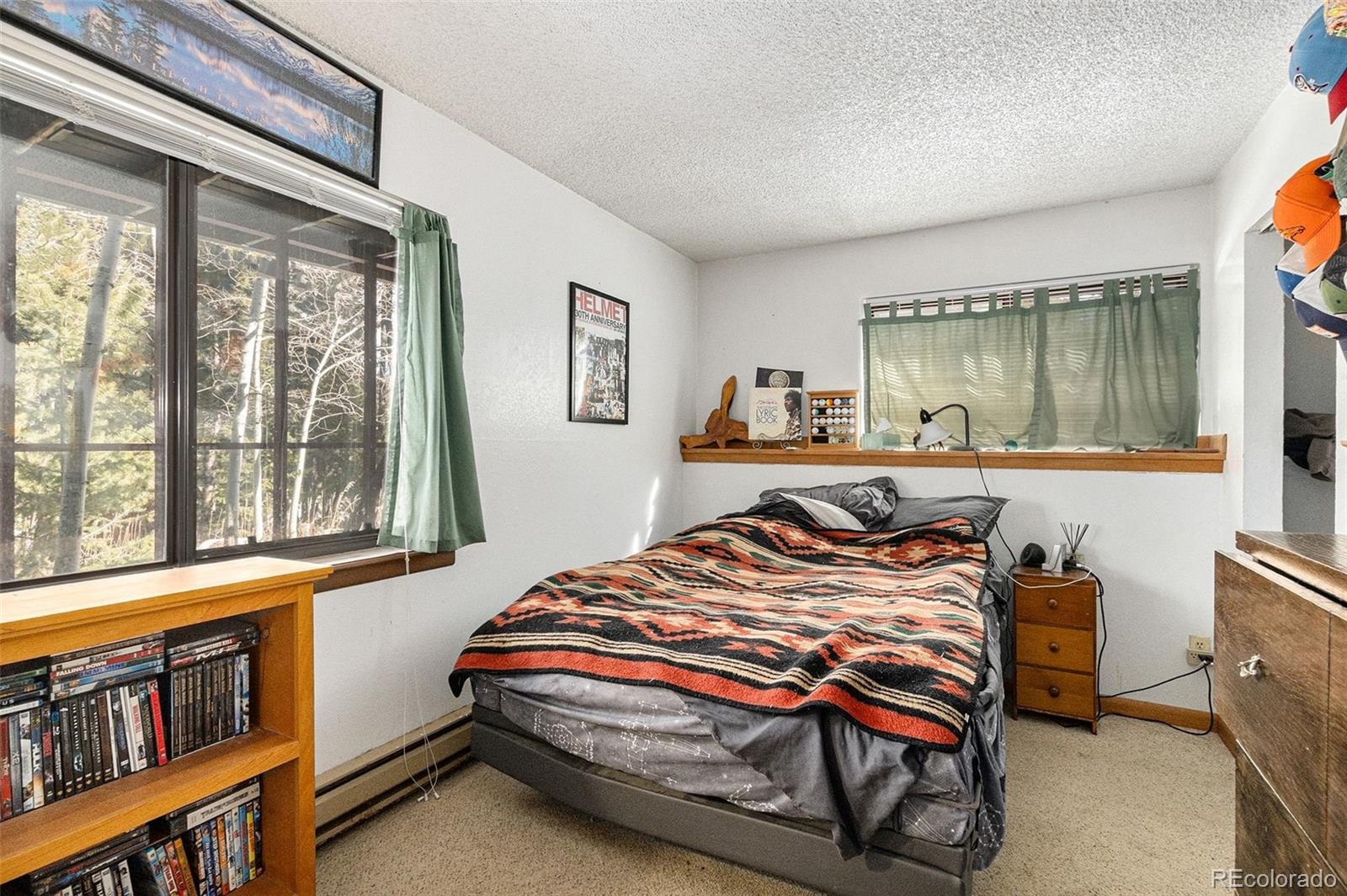 22296 Cook Lane Morrison, CO 80465 - Photo 16 of 19 a bed sitting in a bedroom next to a window