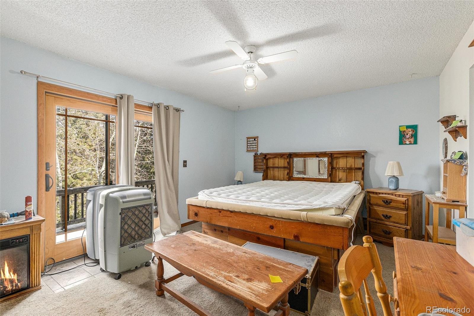 22296 Cook Lane Morrison, CO 80465 - Photo 6 of 19 a bedroom with a bed and a chandelier