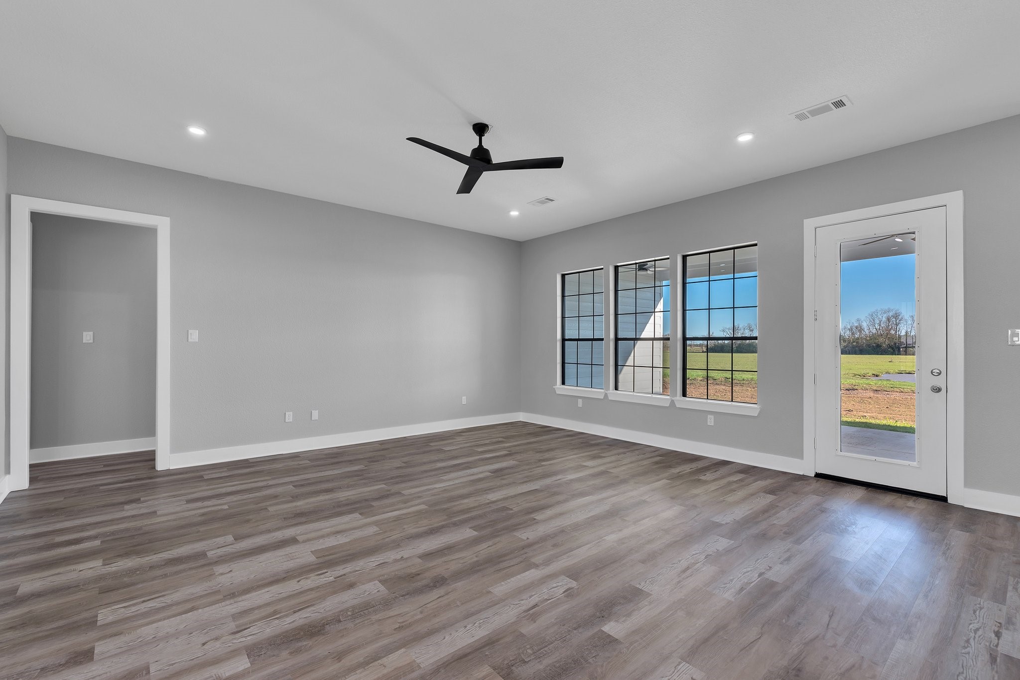 519 Chuckwagon Trail Angleton, TX 77515 - Photo 7 of 34 a view of an empty room with a window and wooden floor