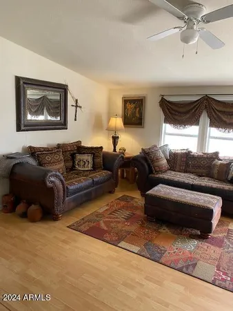 a living room with furniture ceiling fan and a window