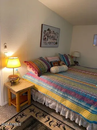 a bedroom with a bed and a lamp on the dresser