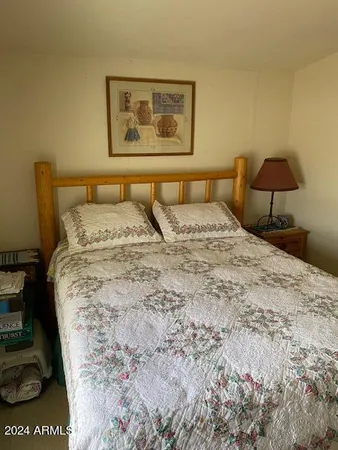 a bedroom with a bed and a lamp on dresser