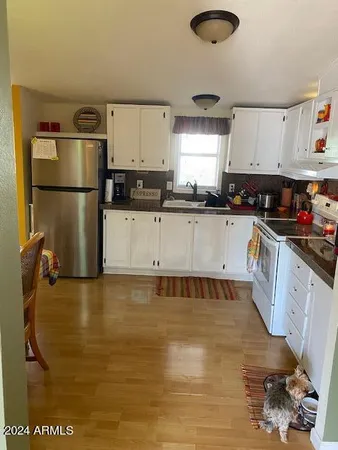a kitchen with granite countertop a sink a stove and refrigerator