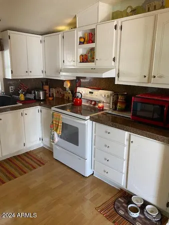 a kitchen with granite countertop white cabinets and white appliances