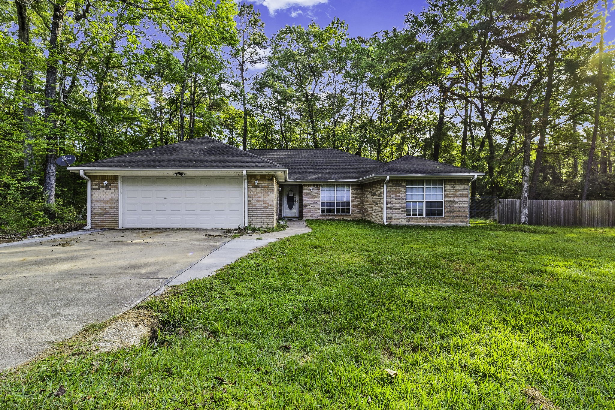 a front view of a house with a garden and trees