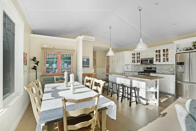 a view of a dining room and livingroom with furniture wooden floor a chandelier