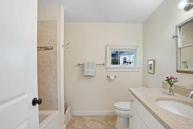a bathroom with a granite countertop toilet a sink and a mirror