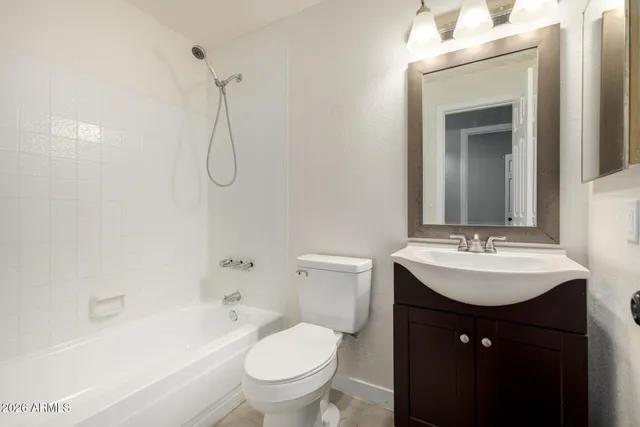 an empty room with ceiling fan and windows