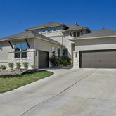 a front view of a house with a garden and garage