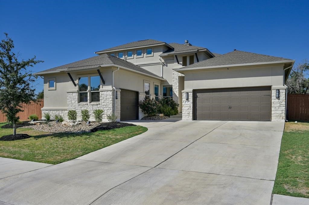 a front view of a house with a garden and garage