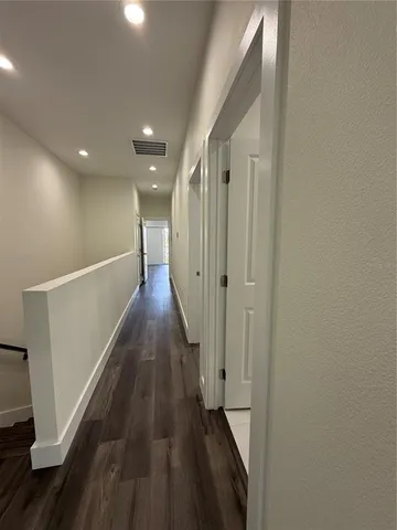 a view of a hallway with wooden floor