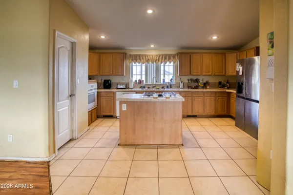 a kitchen with stainless steel appliances granite countertop a stove top oven a sink a counter top space and cabinets