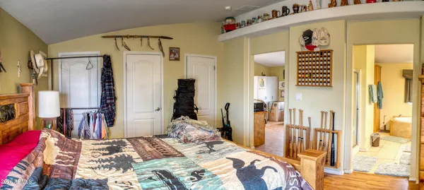 a bedroom with a bed and a large mirror on the dresser