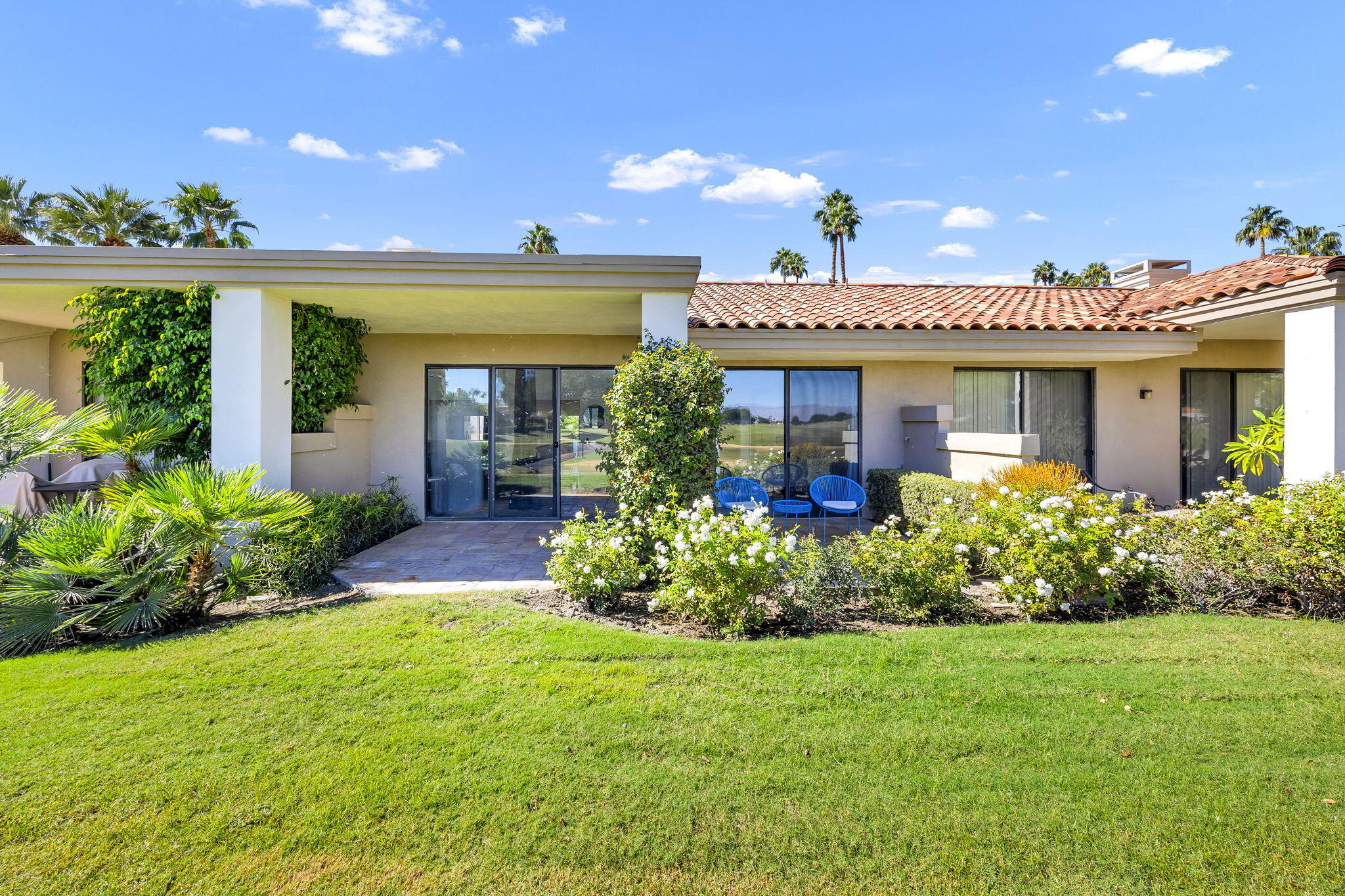 54880 Inverness Way La Quinta, CA 92253 - Photo 16 of 20 a front view of a house with a porch and garden