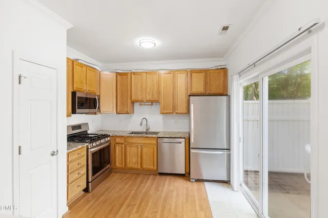 a kitchen with a refrigerator a sink and wooden cabinets