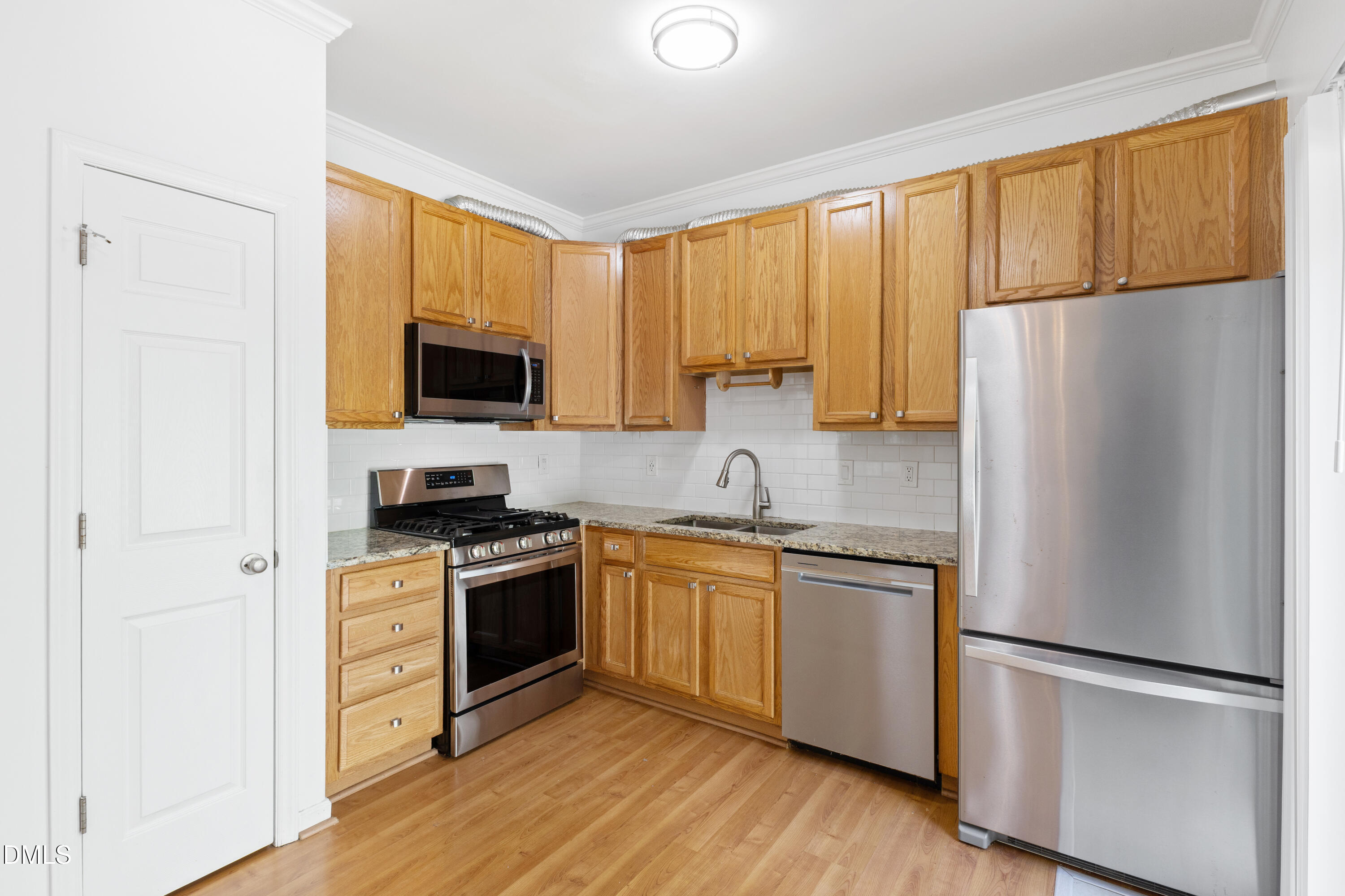 11710 Mezzanine Drive, Unit 101 Raleigh, NC 27614 - Photo 14 of 29 a kitchen with stainless steel appliances a refrigerator sink and microwave