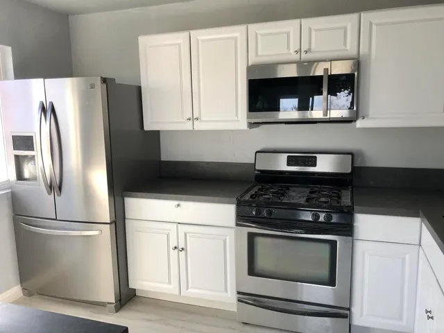 a kitchen with cabinets and stainless steel appliances