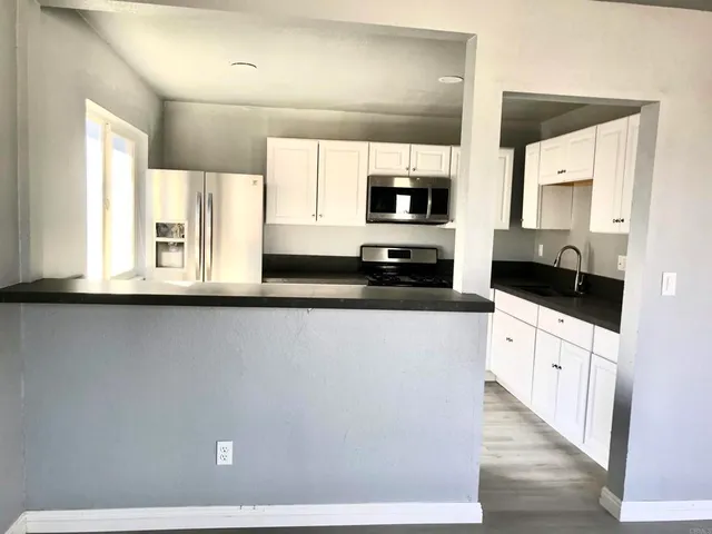 a large white kitchen with a large window