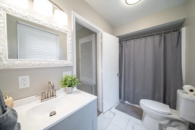 a en suite bathroom with a granite countertop tub and a large window