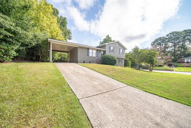 a front view of a house with a yard and trees