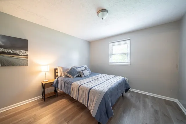 a bedroom with a bed and wooden floor
