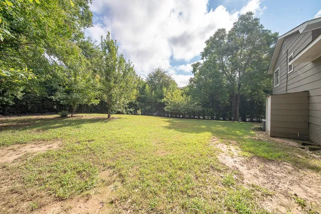 a view of a house with pool and a yard