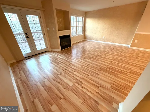 a view of a big room with wooden floor and windows