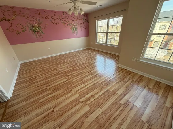 en empty room with windows and ceiling fan