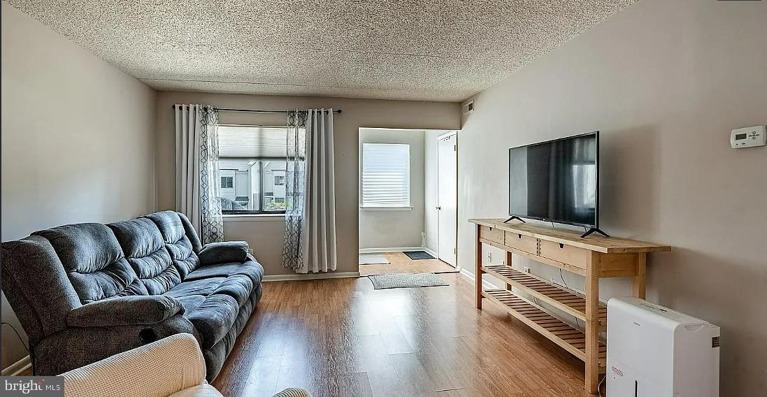 306 Summit House, Unit 306 West Chester, PA 19382 - Photo 4 of 17 a living room with furniture a flat screen tv and a floor to ceiling window