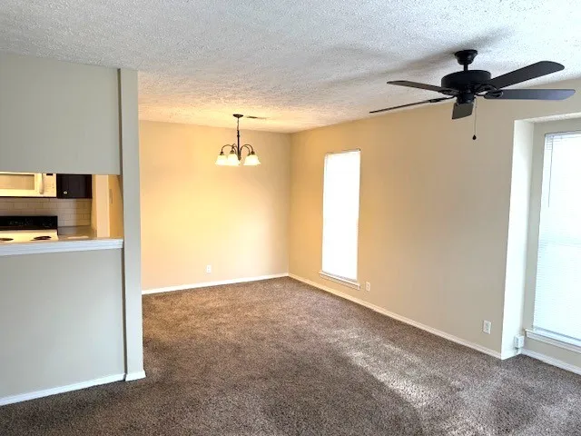 a view of a livingroom with a ceiling fan & a window