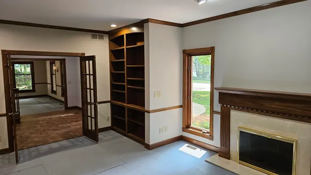 a view of an empty room with wooden floor and a window