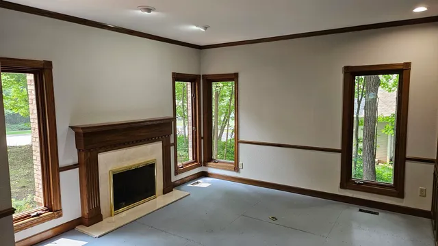 a view of an empty room with a fireplace and a window