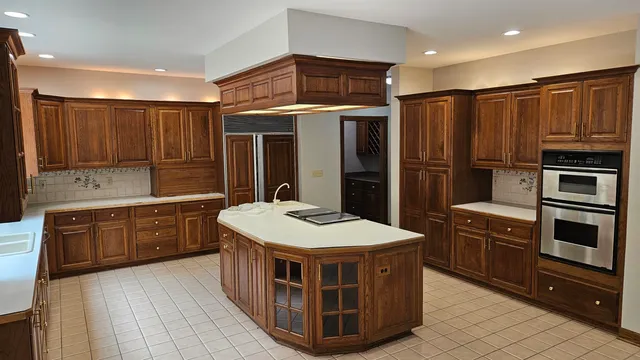 a kitchen with stainless steel appliances granite countertop a stove a sink dishwasher a refrigerator and a oven with wooden floor