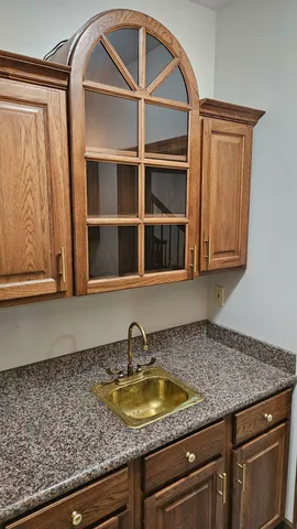 a kitchen with granite countertop a sink and cabinets