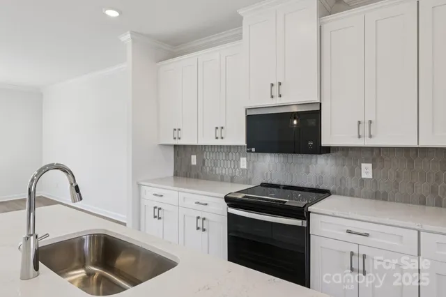 a kitchen with sink a microwave and stove