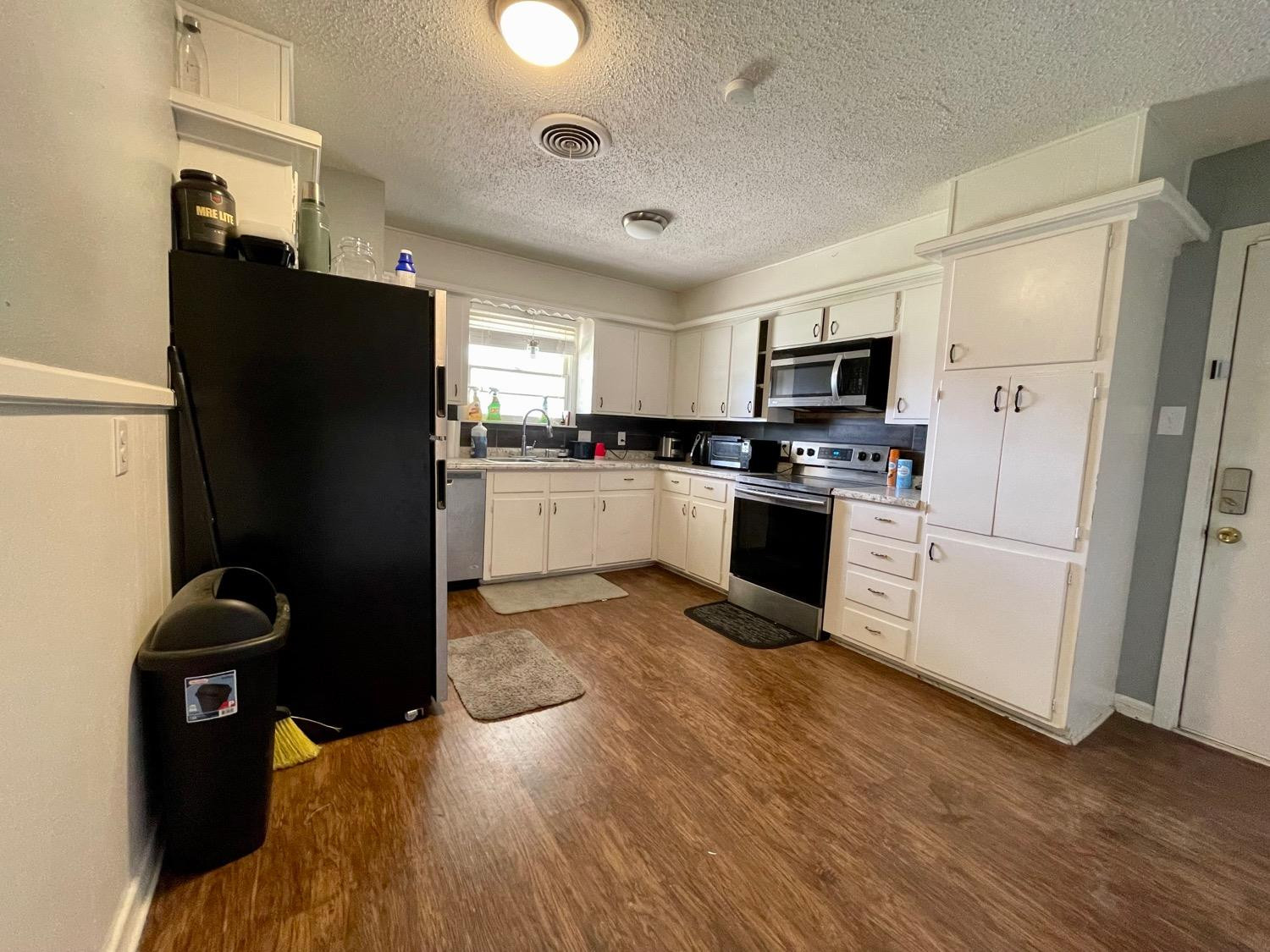 5426 25th Street Lubbock, TX 79407 - Photo 4 of 9 a kitchen with a refrigerator stove and sink