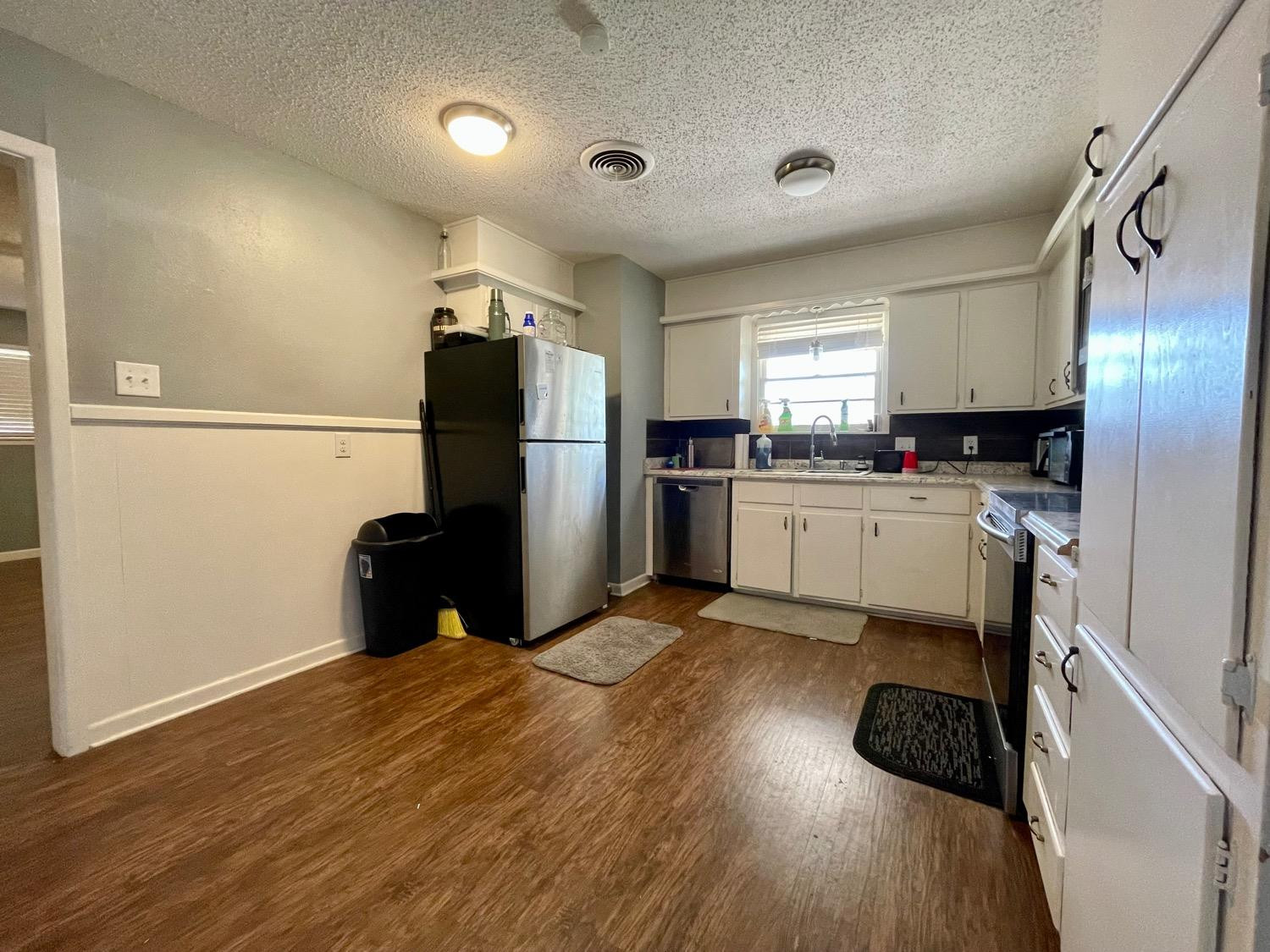 5426 25th Street Lubbock, TX 79407 - Photo 5 of 9 a kitchen with a refrigerator and a stove top oven
