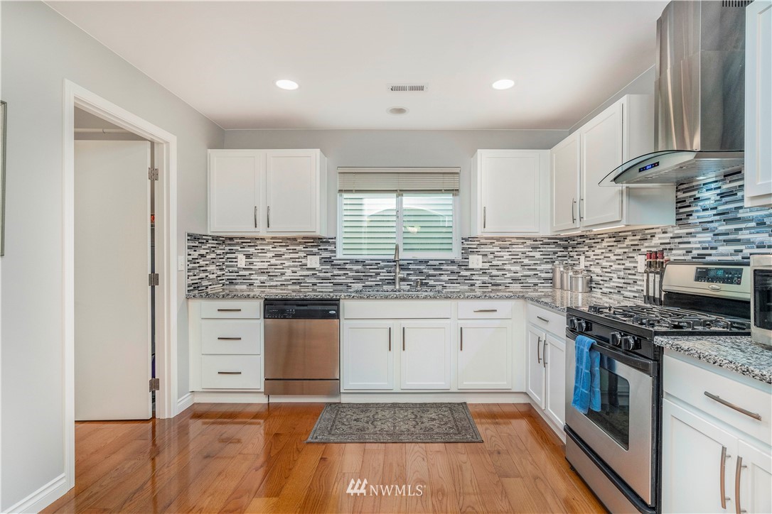 3719 154th Place Southeast Bothell, WA 98012 - Photo 6 of 37 a kitchen with granite countertop a stove sink and cabinets