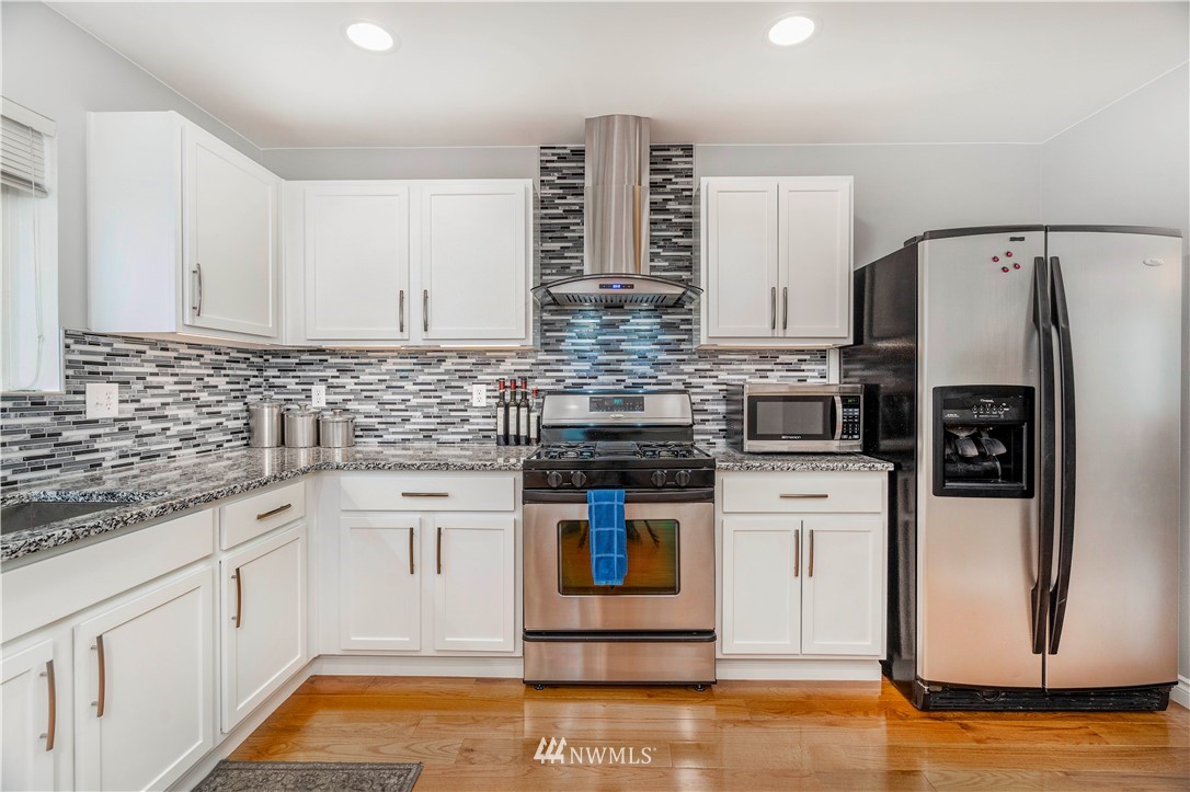 3719 154th Place Southeast Bothell, WA 98012 - Photo 7 of 37 a kitchen with stainless steel appliances kitchen island granite countertop a refrigerator and a stove