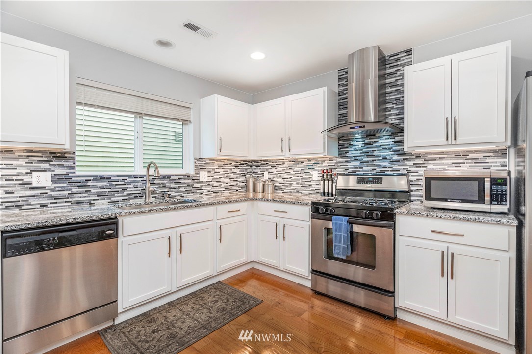 3719 154th Place Southeast Bothell, WA 98012 - Photo 8 of 37 a kitchen with stainless steel appliances granite countertop a stove sink and cabinets