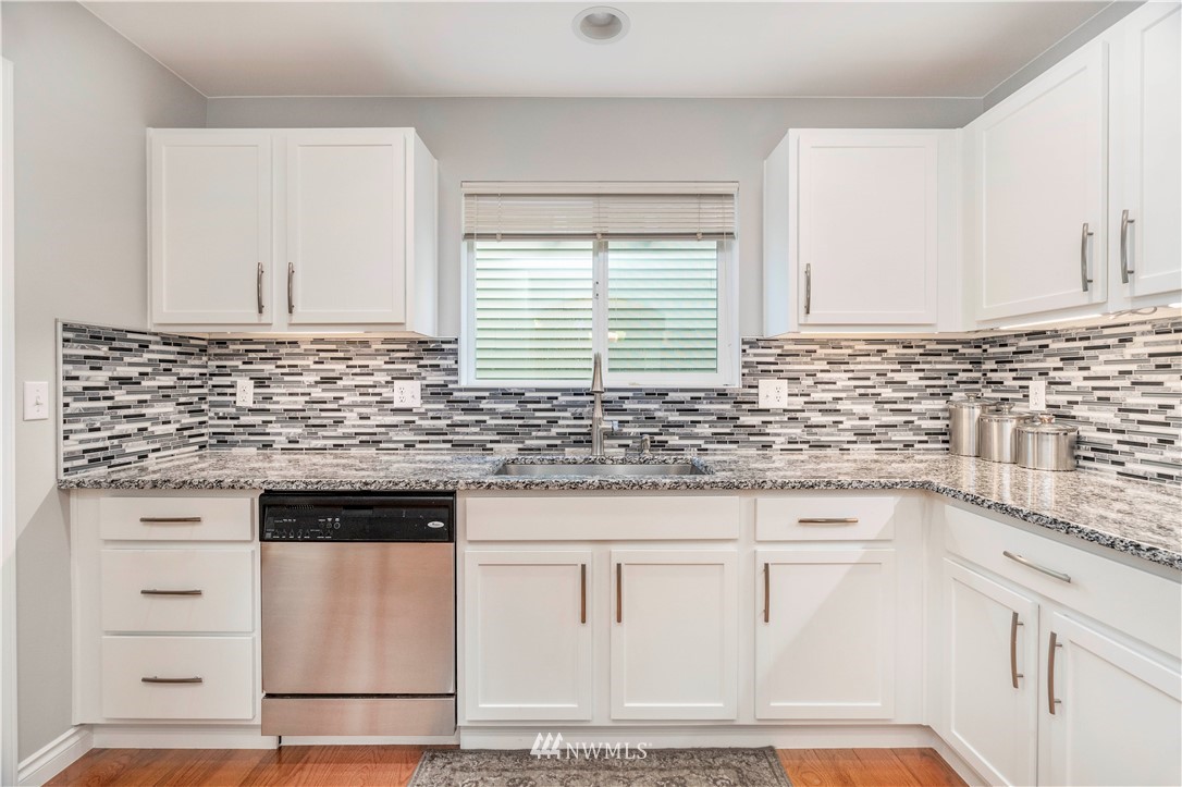 3719 154th Place Southeast Bothell, WA 98012 - Photo 9 of 37 a kitchen with granite countertop white cabinets and white appliances