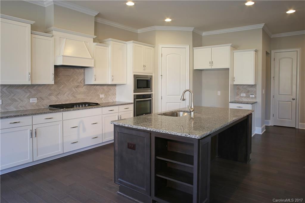 1532 Afton Way, Unit 168 Fort Mill, SC 29708 - Photo 2 of 19 a kitchen with kitchen island granite countertop a stove a sink and white cabinets