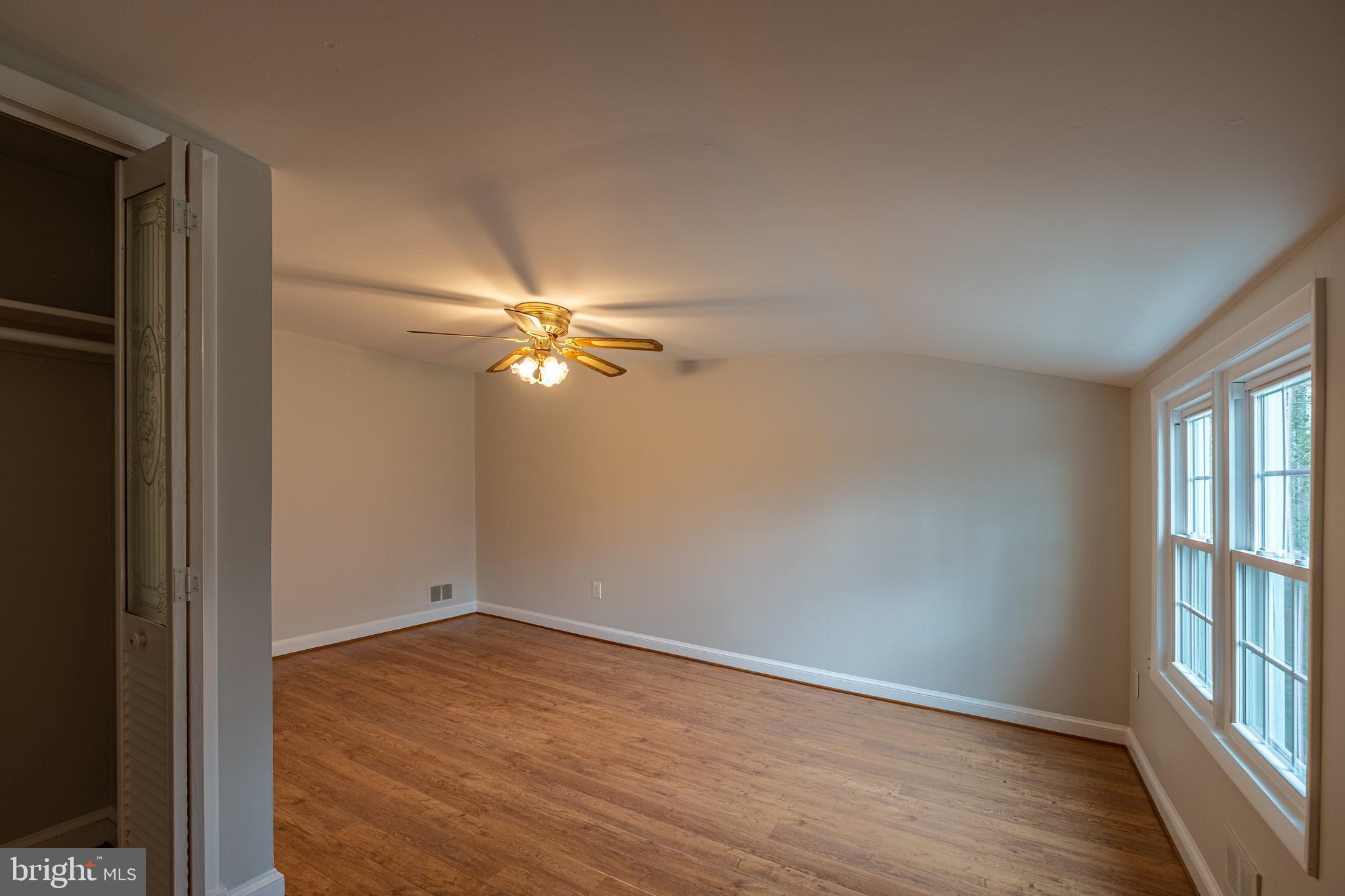 5680 Bryantown Road Bryantown, MD 20617 - Photo 21 of 35 a view of empty room with wooden floor and fan