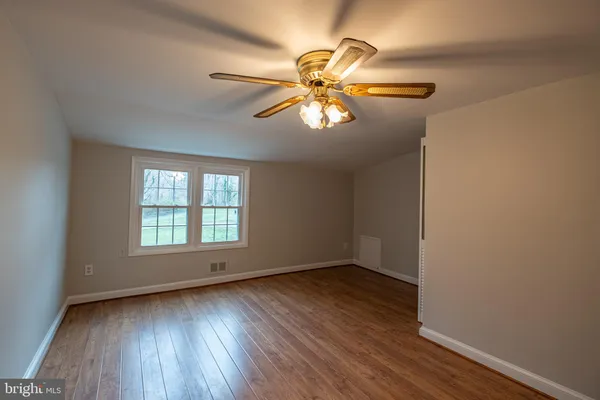 a view of empty room with window and wooden floor