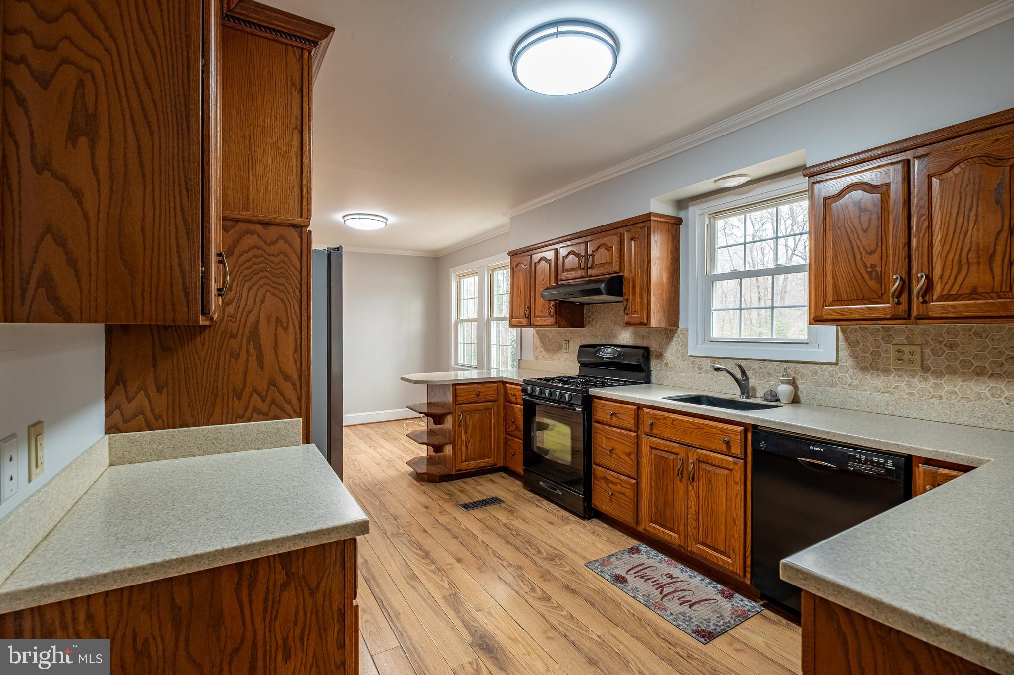 5680 Bryantown Road Bryantown, MD 20617 - Photo 7 of 35 a kitchen with stainless steel appliances granite countertop a sink dishwasher stove and wooden cabinets