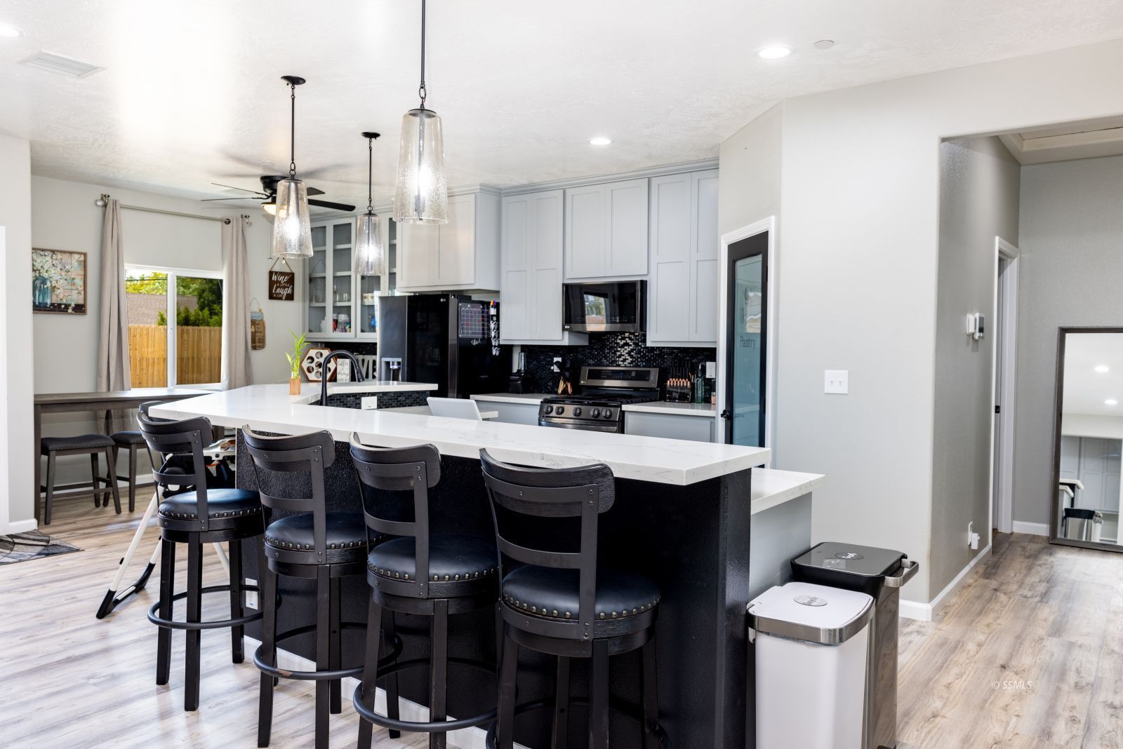 915 West Perch Avenue Ridgecrest, CA 93555 - Photo 12 of 41 a kitchen with stainless steel appliances kitchen island granite countertop a dining table chairs and white cabinets