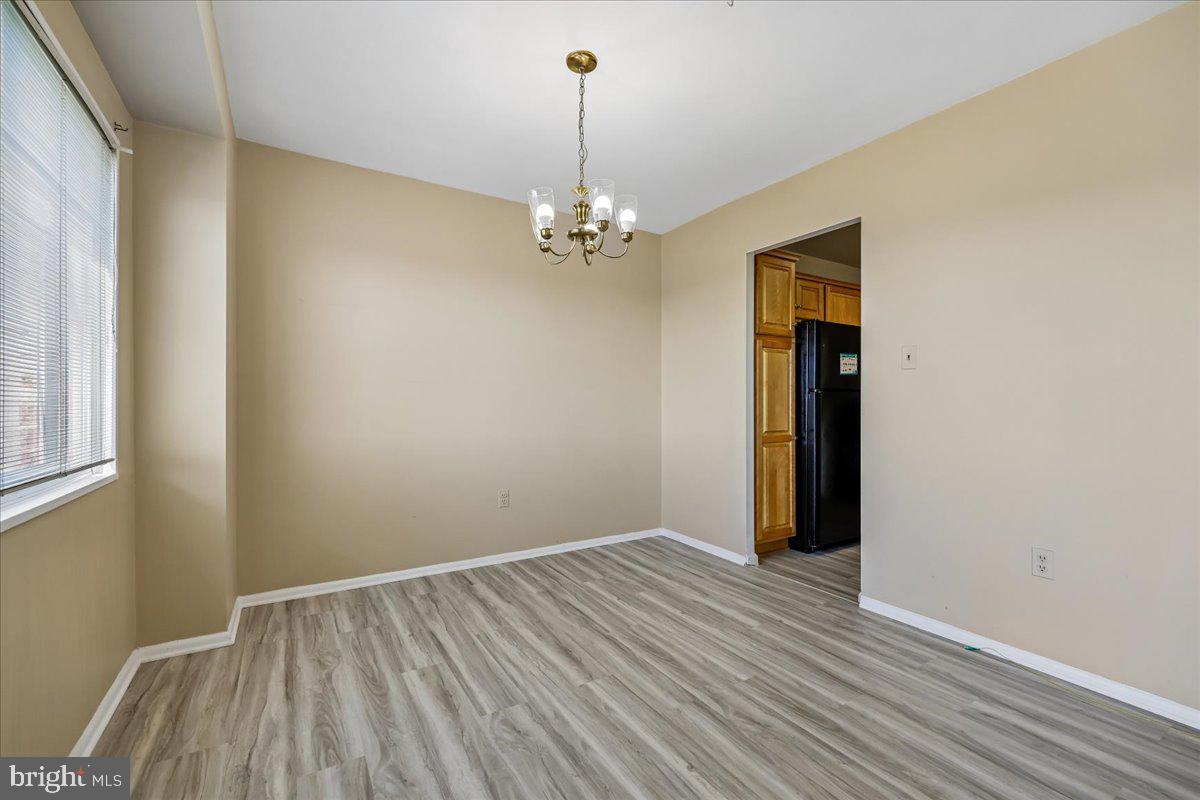 1111 University Boulevard West, Unit 1106A Silver Spring, MD 20902 - Photo 9 of 35 a view of a room with wooden floor chandelier and closet