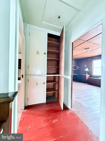 a view of an empty room with cabinet and a window